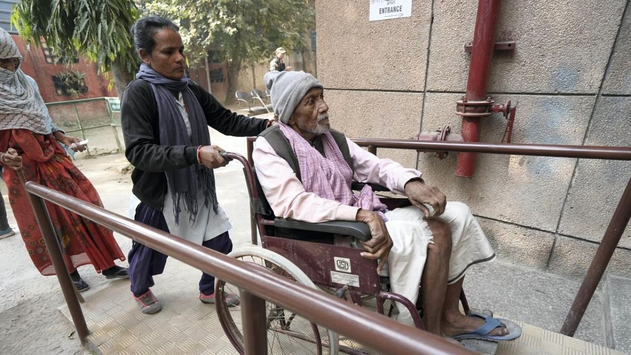 A wheelchair bound voter arrives to cast his vote for the Municipal Corporation of Delhi (MCD) elections, at a polling station in Majnu-ka-tilla area, in North Delhi. Credit: PTI Photo