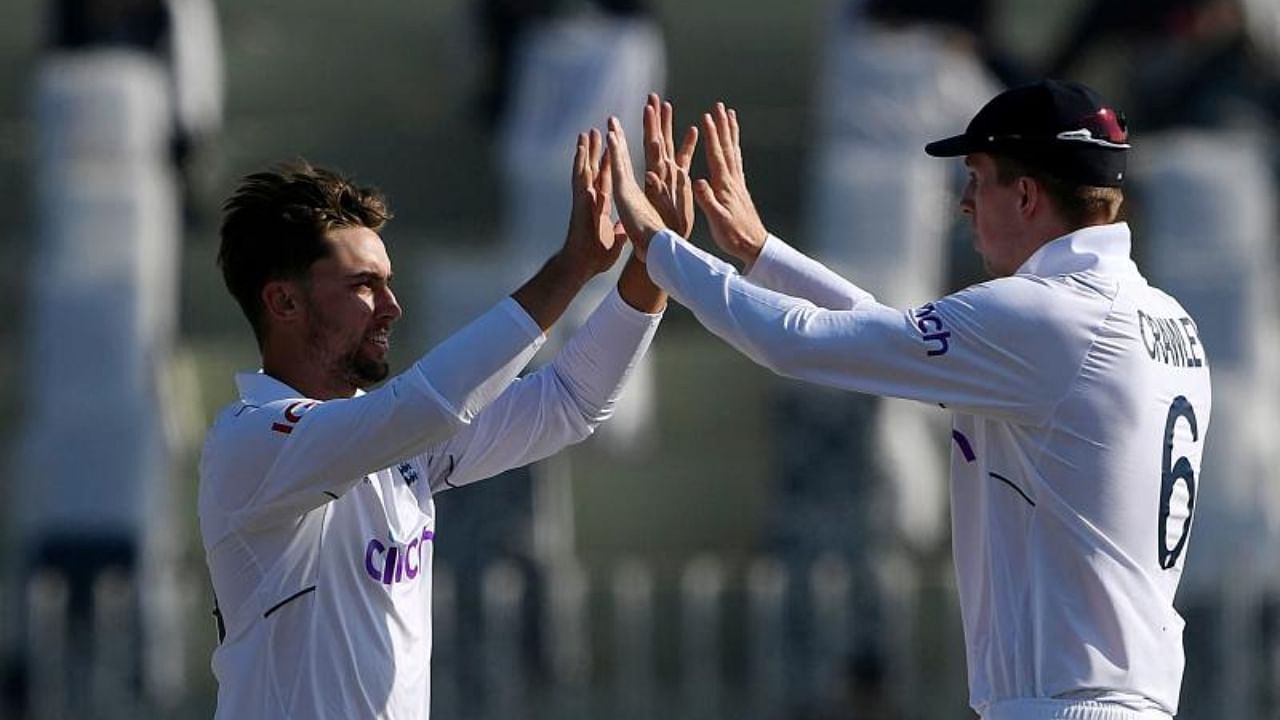 England's Will Jacks (L) celebrates with teammate Zak Crawley after taking the wicket of Pakistan's Salman Ali Agha (not pictured) during the fourth day of the first cricket Test match between Pakistan and England at the Rawalpindi Cricket Stadium, in Rawalpindi on December 4, 2022. Credit: AFP Photo