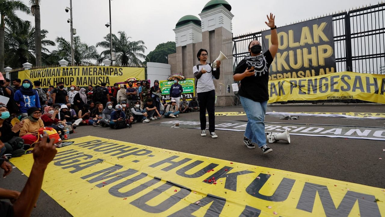 An activist shouts slogans during a protest, as Indonesia is set to pass a new criminal code that will ban sex outside marriage, cohabitation between unmarried couples, insulting the president, and expressing views counter to the national ideology, outside the Indonesian Parliament buildings in Jakarta, Indonesia. Credit: Reuters photo