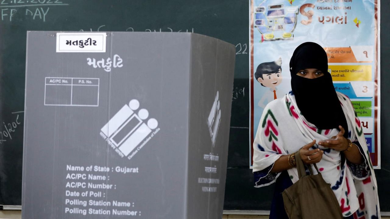 A woman leaves a polling booth after casting her vote during the second and last phase of Gujarat Assembly election in Ahmedabad. Credit: Reuters photo