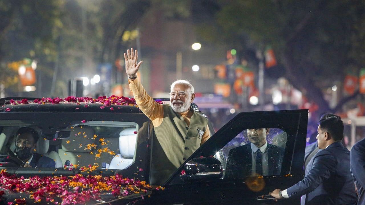Prime Minister Narendra Modi waves at supporters during his election campaign roadshow for Gujarat Assembly polls. Credit: PTI Photo
