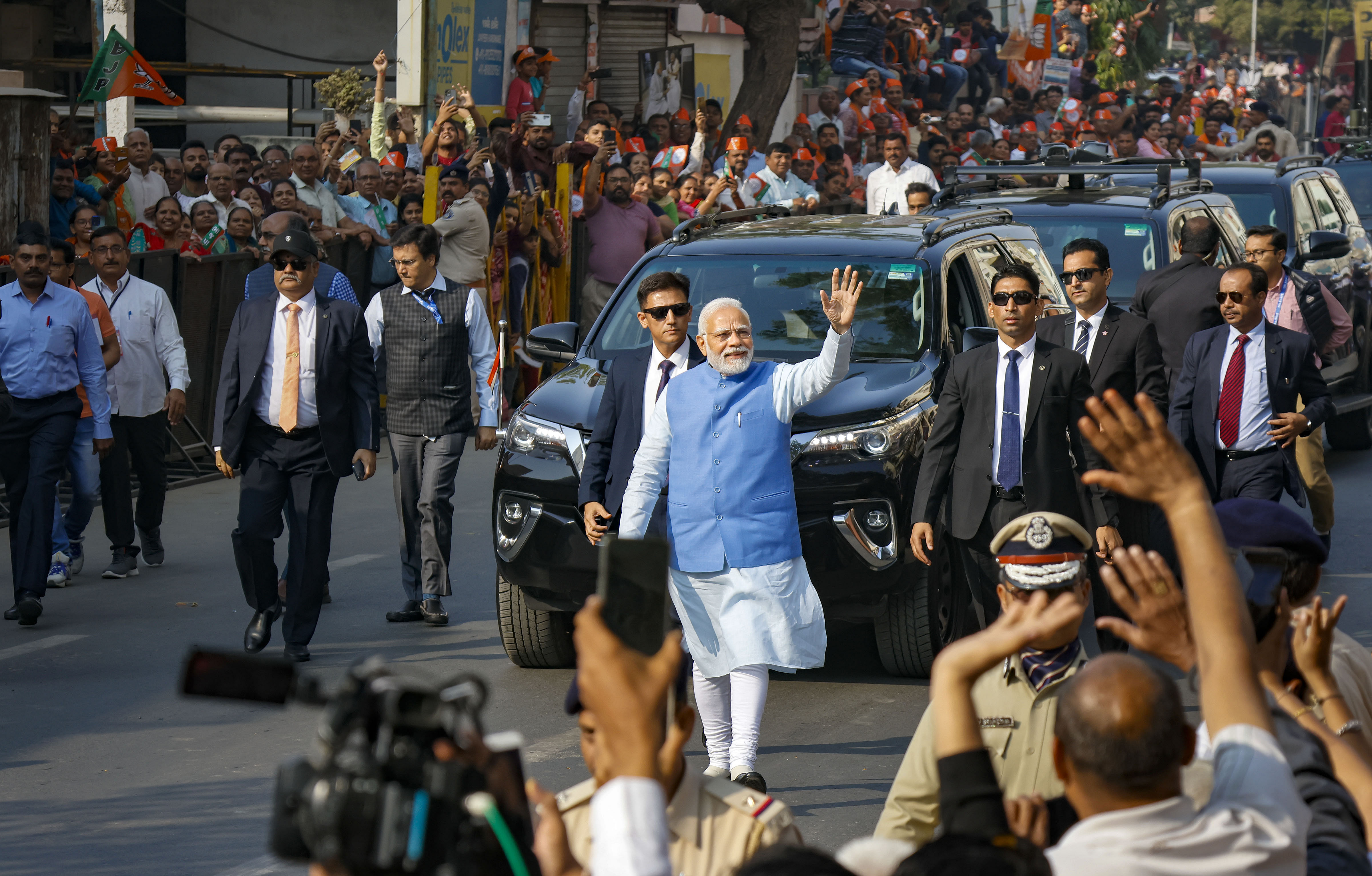 Prime Minister Narendra Modi waves at supporters as he leaves after casting his vote at a polling booth during the second and final phase of Gujarat Assembly elections, at Ranip area in Ahmedabad. Credit: PTI Photo