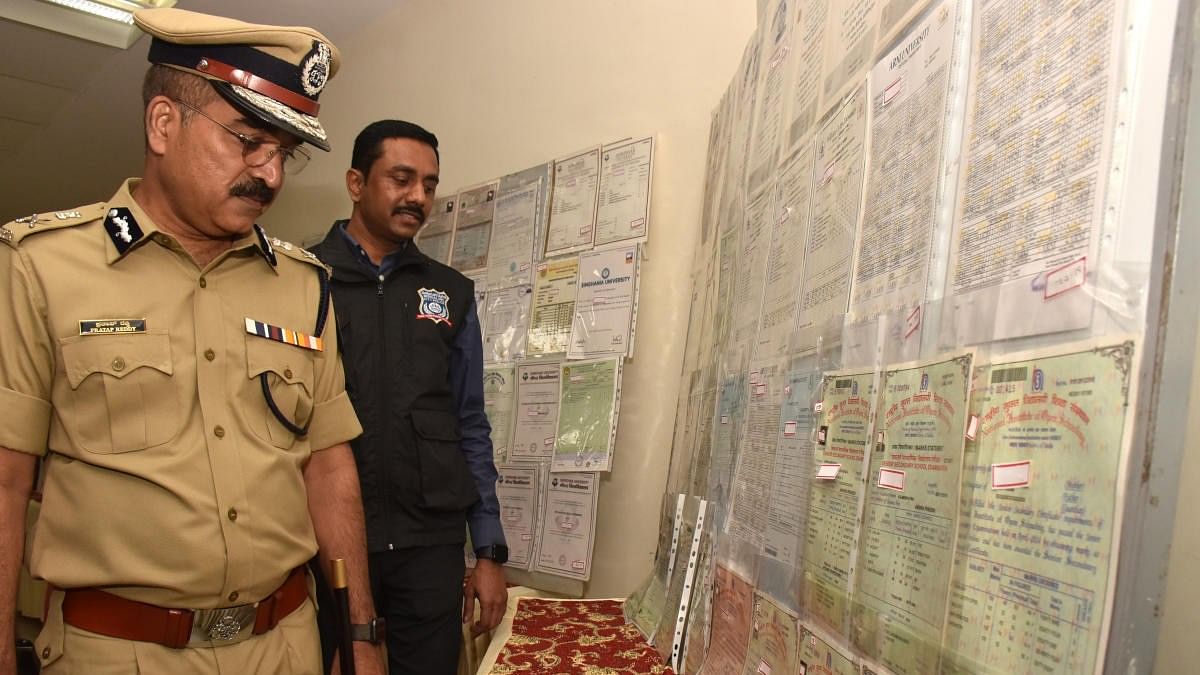 Bengaluru Police Commissioner C H Pratap Reddy inspects the fake documents seized during the raid. DH Photo/B K Janardhan