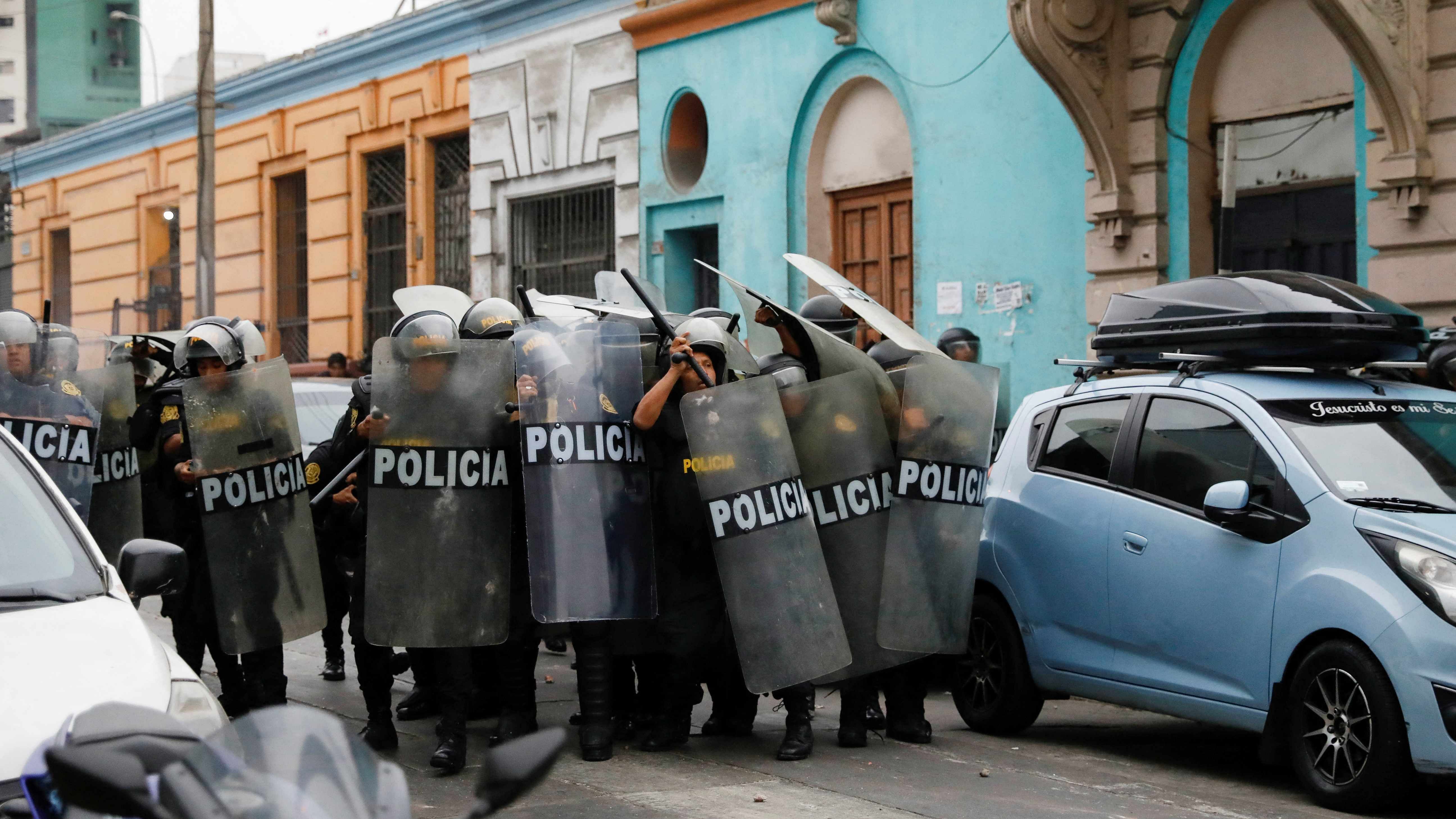 Police officers hold their shields during a protest near Lima's Prefecture where President Pedro Castillo was reportedly staying, after Congress approved the removal of Castillo. Credit: Reuters Photo