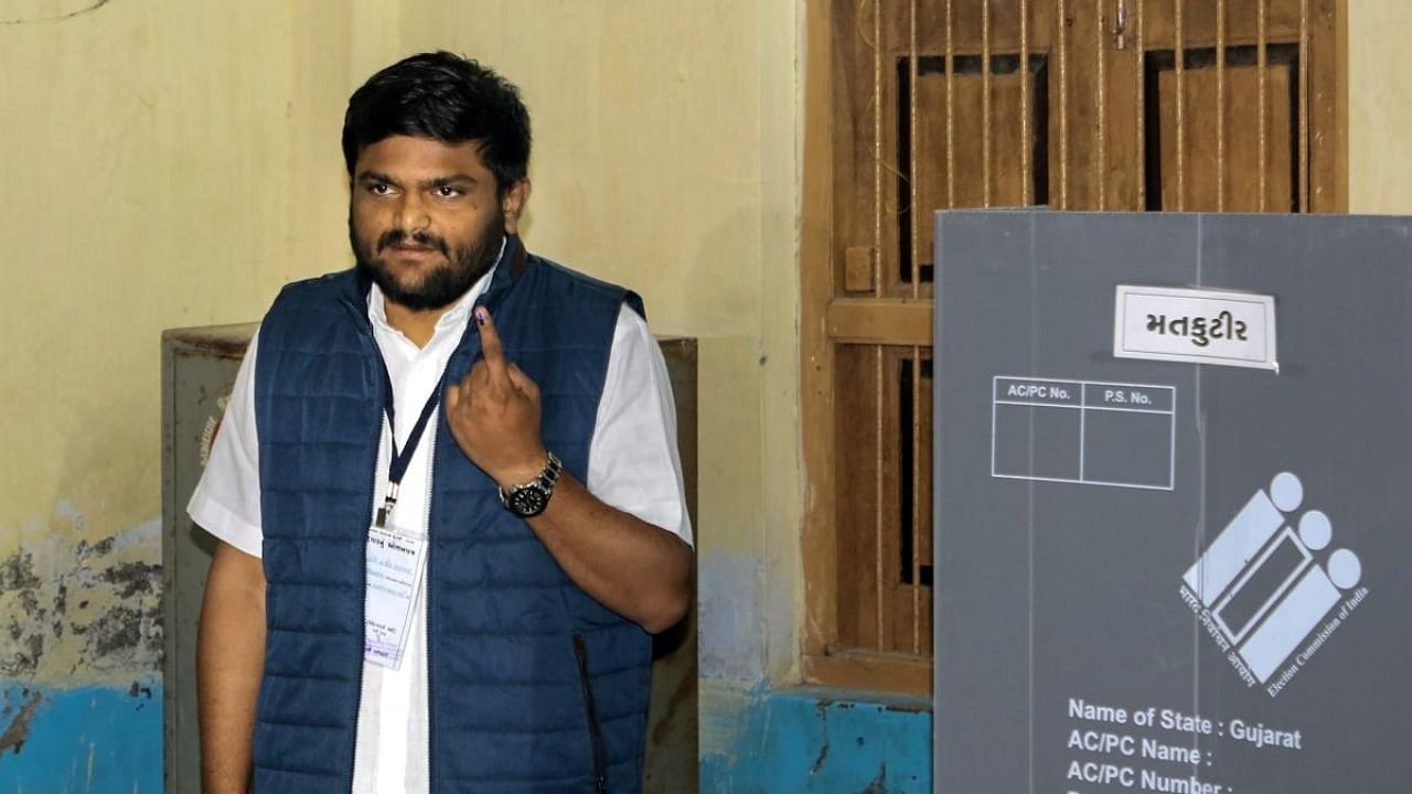 BJP candidate from Viramgam Hardik Patel shows his finger marked with indelible ink after casting his vote at a polling booth. Credit: PTI Photo