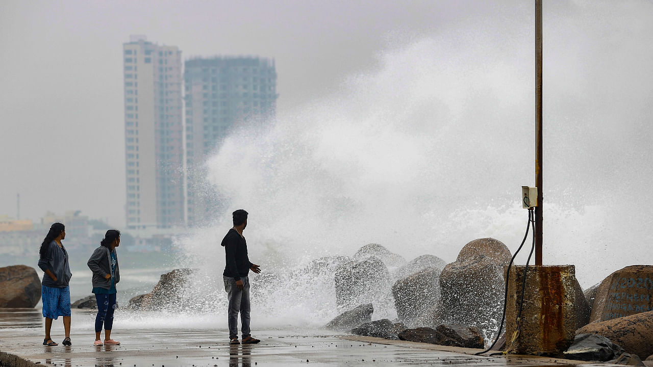 Youngsters react as sea waves crash at the sea-shore ahead of the landfall of cyclonic storm Mandous, in Chennai. Credit: PTI Photo
