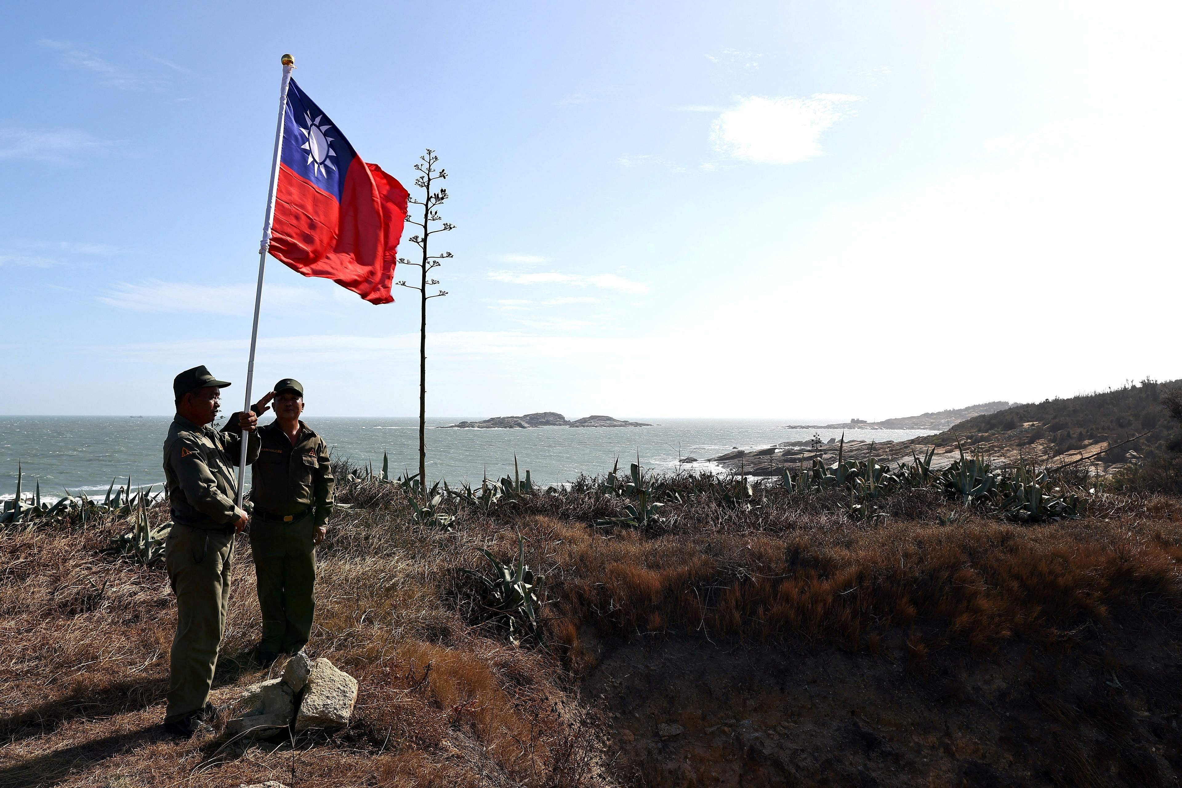 Veterans take part in a flag raising ceremony at a former military post on Kinmen, Taiwan, October 15, 2021. Sitting on the front line between Taiwan and China, Kinmen is the last place where the two engaged in major fighting, in 1958. Credit: Reuters Photo