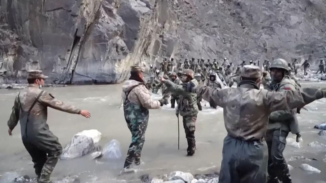 This video frame grab taken from footage recorded in mid-June 2020 and released by China Central Television (CCTV) on February 20, 2021 shows Chinese (foreground) and Indian soldiers (R, background) during an incident where troops from both countries clashed in the Line of Actual Control (LAC) in the Galwan Valley, in the Karakoram Mountains in the Himalayas. Credit: CCTV / AFP Photo