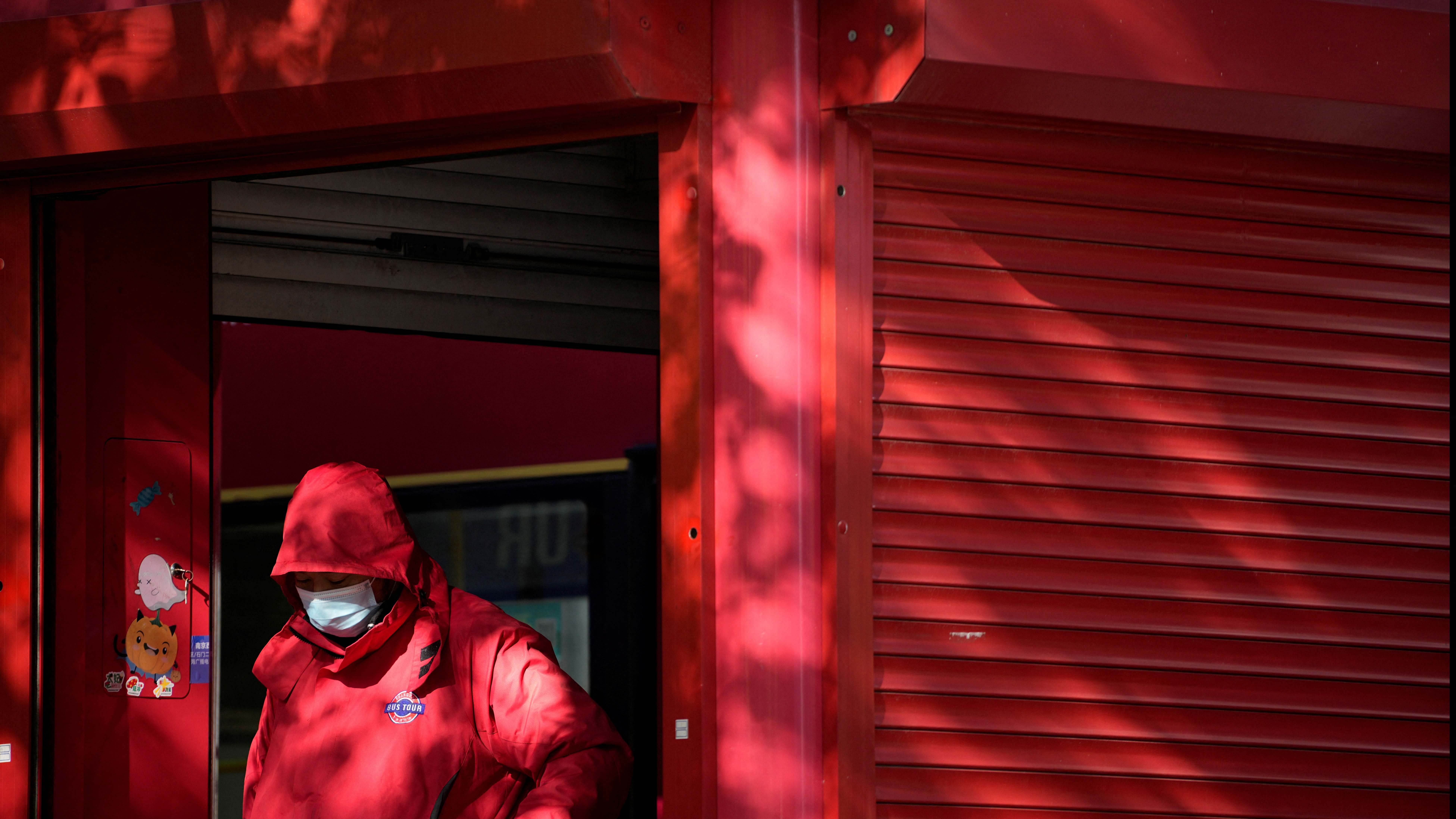 A bus conductor wearing a face mask stands at a bus station, as coronavirus disease outbreaks continue in Shanghai, China. Credit: Reuters Photos