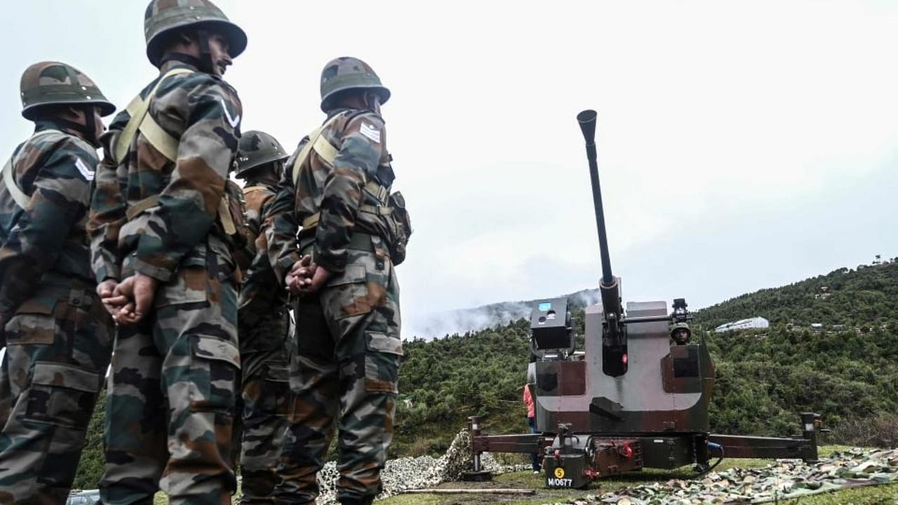 Indian Army soldiers stand next to an upgraded L70 anti aircraft gun in Tawang near the Line of Actual Control (LAC), in Arunachal Pradesh. Credit: AFP Photo