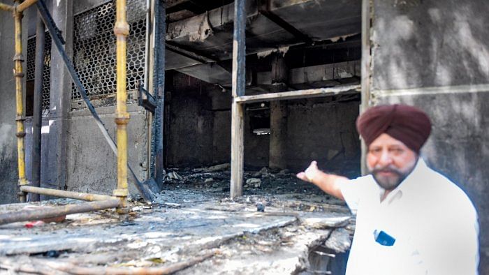 A man shows charred remains after a fire at Uphaar Cinema, which has been shut since 1997 following a blaze that killed 59 people. Credit: PTI File Photo