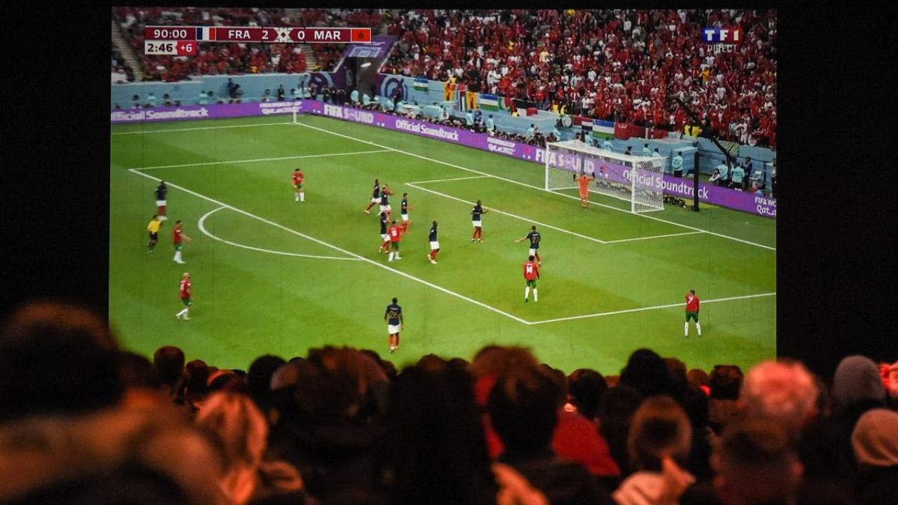 Football fans watch on a giant screen the Qatar 2022 World Cup semi-final football match between France and Morocco in Saint-Nazaire, western France. Credit: AFP Photo