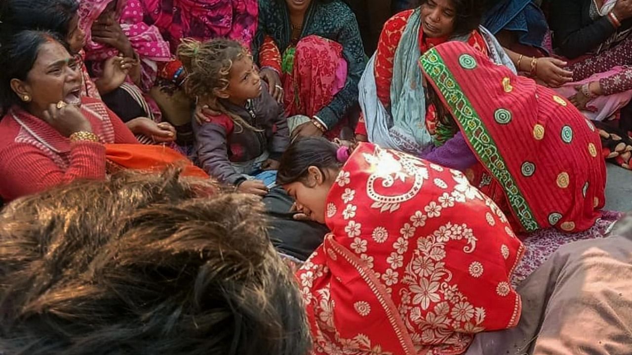 Family members and relatives of people, who died after consuming allegedly spurious liquor mourn near their mortal remains, at Ishuapur police station area in Bihar's Saran district. Credit: PTI Photo