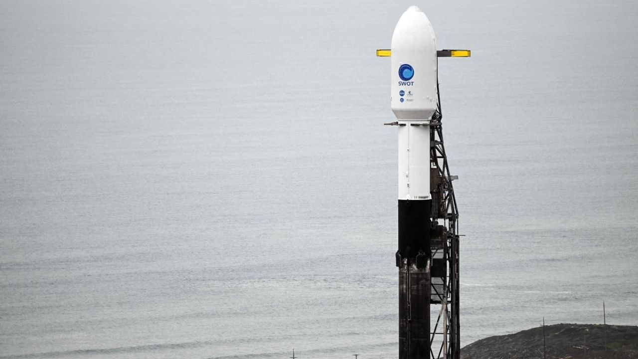 A SpaceX Falcon 9 rocket stands on a launch pad with the Surface Water and Ocean Topography (SWOT) satellite from NASA and France's space agency CNES. Credit: AFP Photo