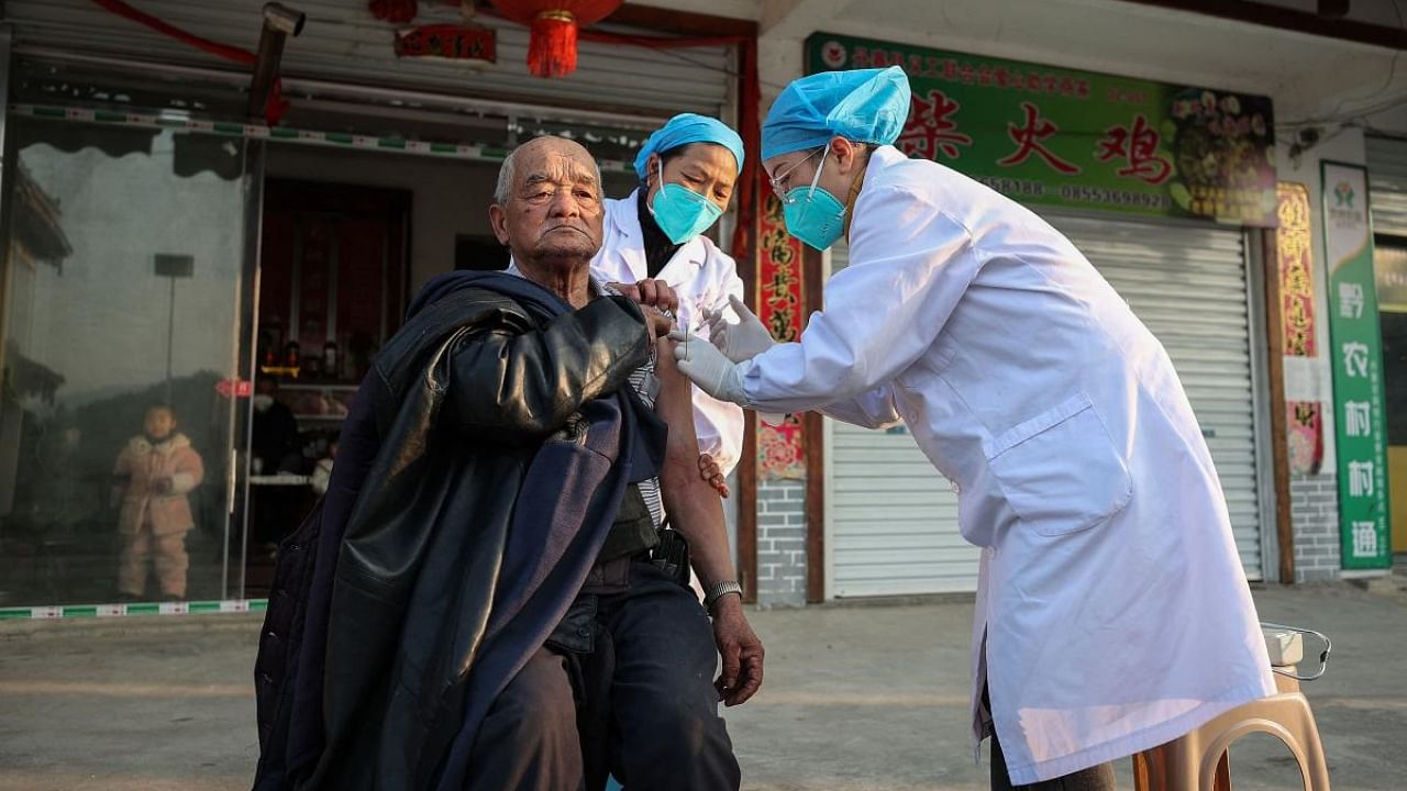 A resident (L) receives a Covid-19 vaccine in Danzhai county, Qiandongnan Miao and Dong Autonomous Prefecture, in China's southwestern Guizhou province on December 12, 2022, as medical workers vaccinate people who can't go out conveniently from their homes. Credit: AFP Photo for representation