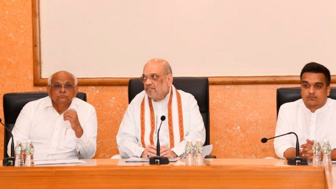 Gujarat Chief Minister Bhupendra Patel (L) and Union Home Minister Amit Shah (C) hold a review meeting on the preparation for the Olympics. Credit: PTI Photo