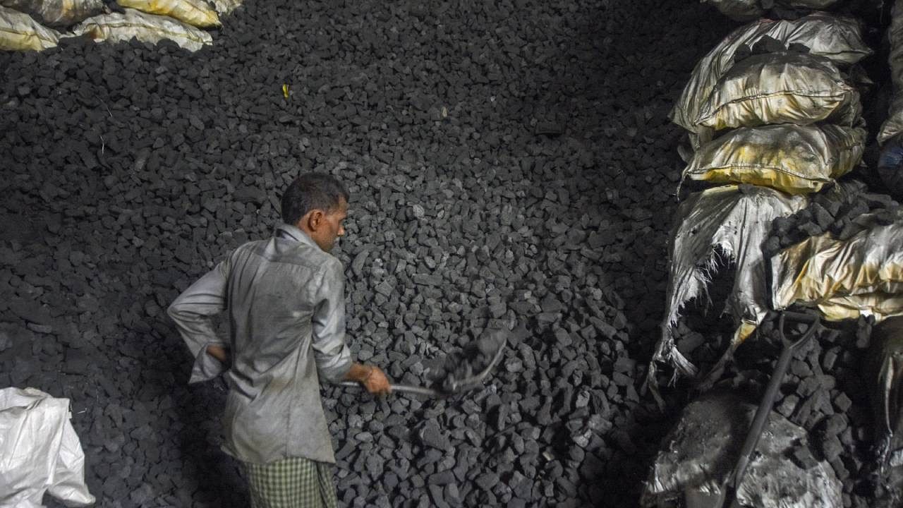 A worker loads coal into a sack at a coal wholesale market in Mumbai. Credit: PTI File Photo