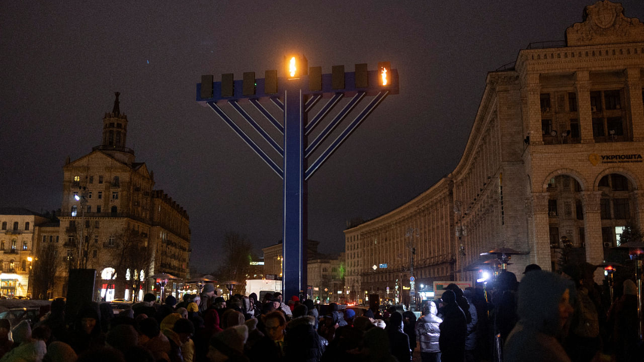 People stand next to a giant menorah during a ceremony for the Jewish festival of Hanukkah, amid Russia’s attack on Ukraine, at the Independence Square in Kyiv, Ukraine. Credit: Reuters Photo