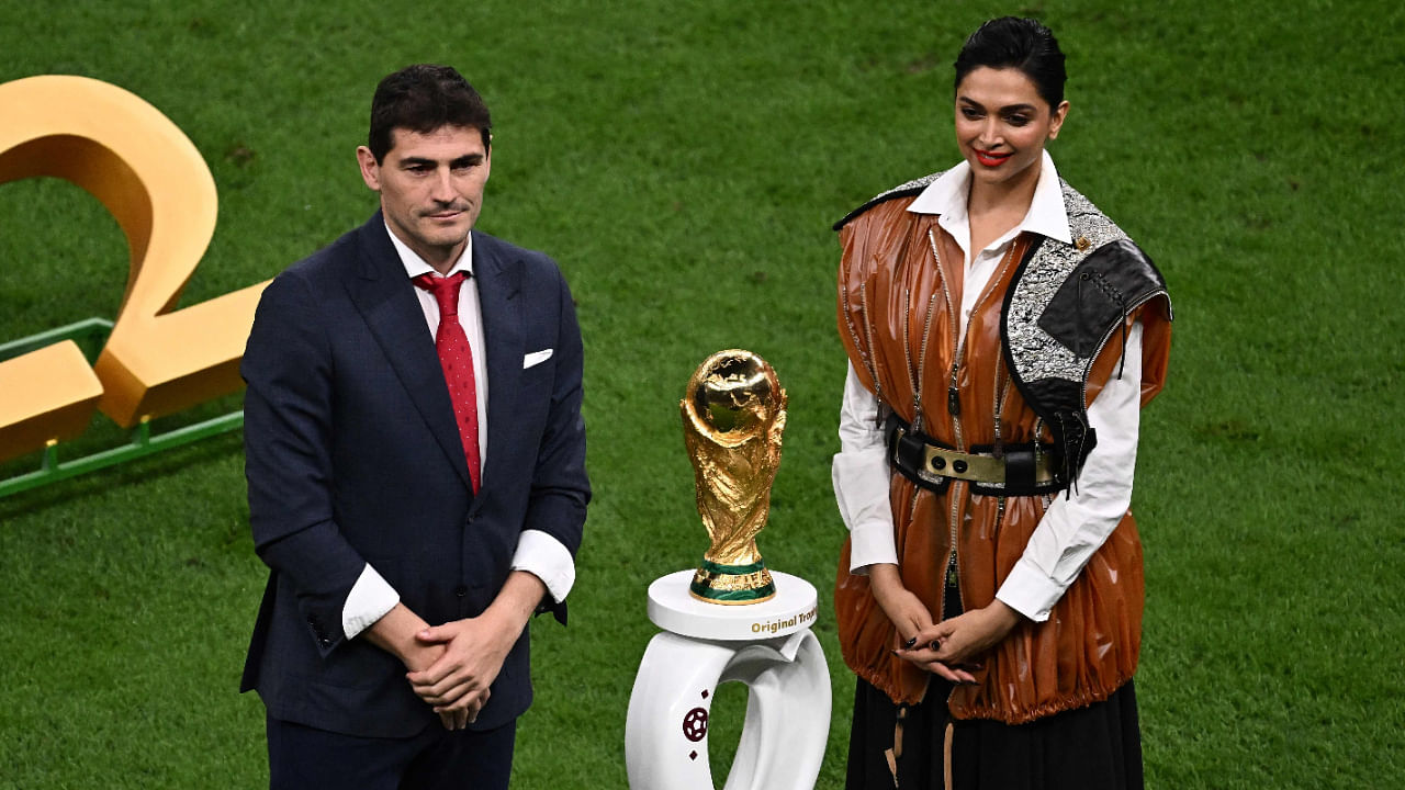 Former Spanish footballer and World Cup winner Iker Casillas (L) and Bollywood actress Deepika Padukone stand next to the World Cup Trophy before the start of the Qatar 2022 World Cup final football match between Argentina and France. Credit: AFP Photo