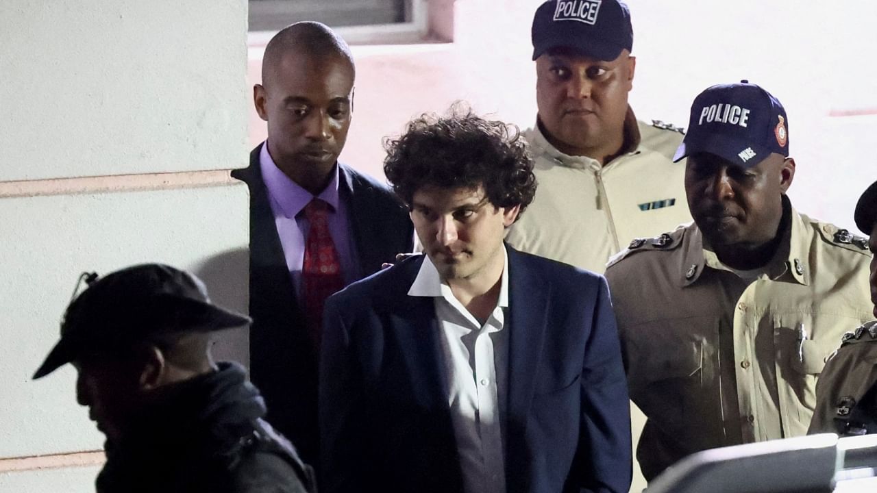 Sam Bankman-Fried, who founded and led FTX until a liquidity crunch forced the cryptocurrency exchange to declare bankruptcy, is escorted out of the Magistrate Court building after his arrest, in Nassau, Bahamas December 13, 2022. Credit: Reuters File Photo