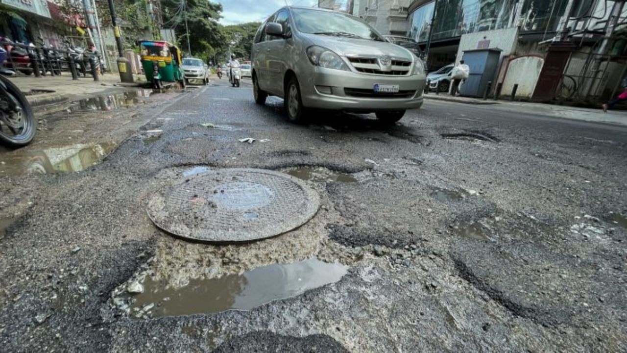 Commuters navigate through several potholes developed on Richmond Road, Bengaluru. Credit: DH Photo