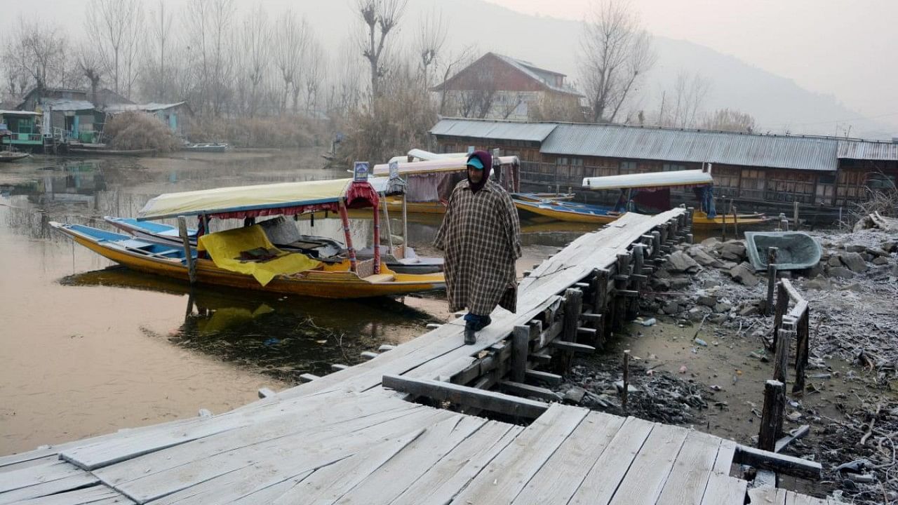 A man walks on frost-covered area as the 40-days harshest winter period Chillai Kalan begins, in Srinagar. Credit: PTI Photo