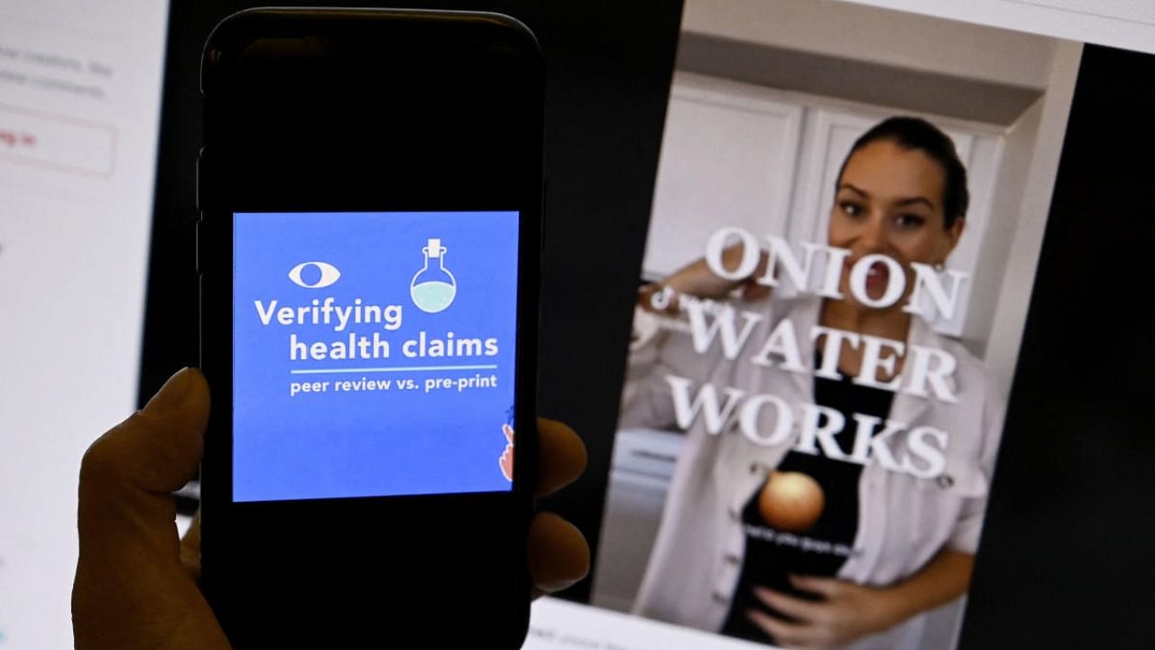 In this photo illustration, a verifying health claims page from AFP Fact Check is displayed on a mobile phone with a TikTok video of Onion Water shown in the background in Washington, DC on December 20, 2022. Credit: AFP Photo