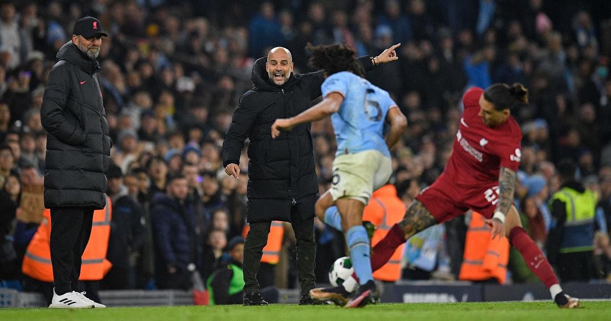 Liverpool's German manager Jurgen Klopp (L) and Manchester City's Spanish manager Pep Guardiola react as Manchester City's Dutch defender Nathan Ake vies with Liverpool's Uruguayan striker Darwin Nunez during the English League Cup fourth round football match between Manchester City and Liverpool. Credit: AFP Photo