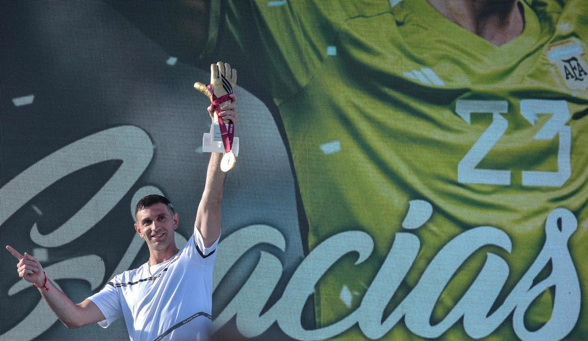 The goalkeeper of the Argentine soccer team Emiliano Martinez, holds gold medal and gold glove trophy awarded by FIFA during a tribute to him, in Mar del Plata, Argentina. Credit: AFP Photo