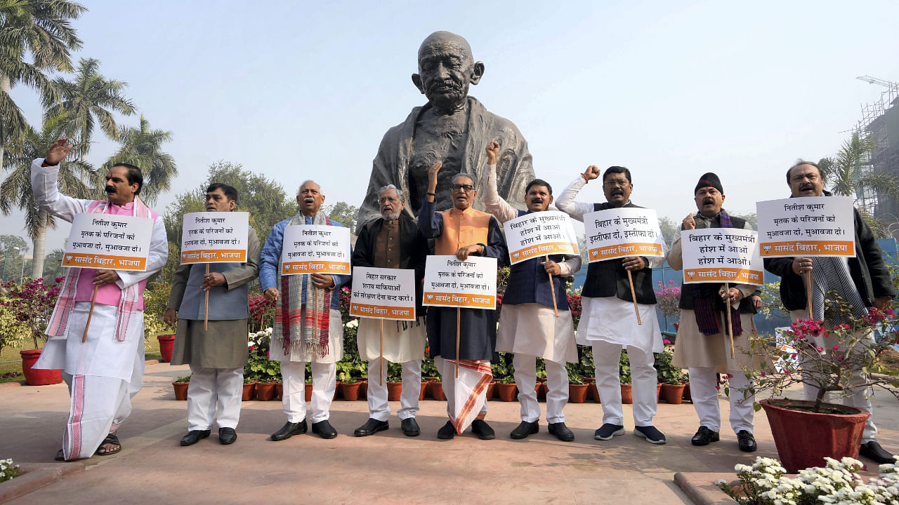 Bihar BJP members stage a protest near the Gandhi Statue demanding compensation for the victims of Saran hooch tragedy, during Winter Session of Parliament, in New Delhi. Credit: PTI Photo
