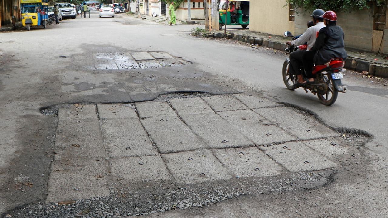 A majority of roads in OMBR Layout, East Bengaluru, are punctuated with potholes or are poorly patched up. Credit: DH Photo/Jimmy James