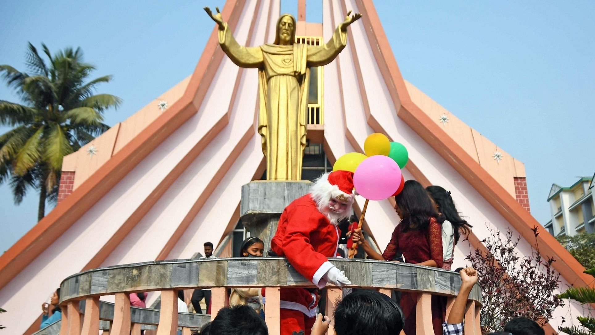 A man dressed as a Santa Claus distributes candy at a church during the Christmas celebrations, in Guwahati. Credit: IANS Photo