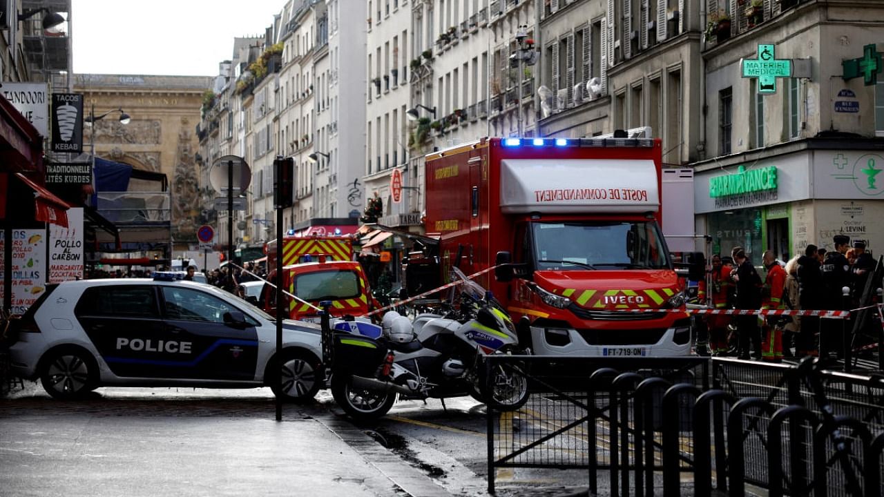 French police and firefighters secure a street after gunshots were fired, killing two people and injuring several, in a central district of Paris. Credit: Reuters photo