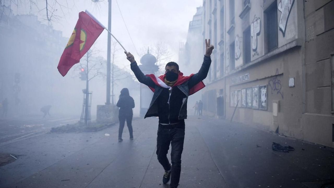 A protester holds a PKK flag during clashes following a demonstration of supporters and members of the Kurdish community in Paris. Credit: AFP Photo