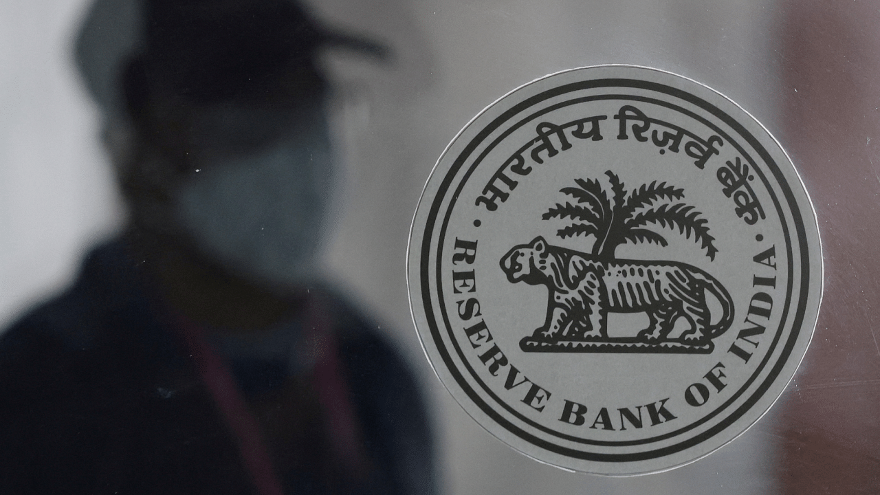 A man walks behind the Reserve Bank of India (RBI) logo inside its headquarters in Mumbai. Credit: Reuters Photo