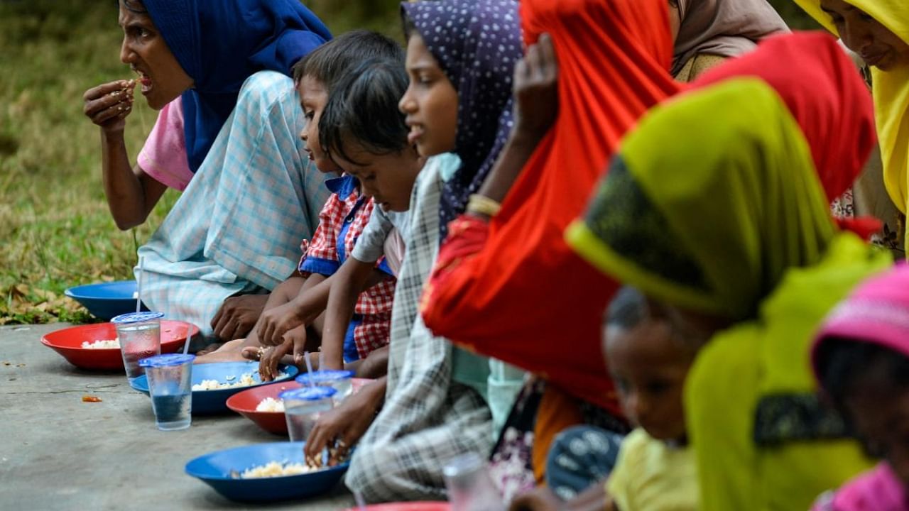 Rohingya refugees eat food in a temporary shelter following their arrival by boat in Laweueng, Aceh province on December 27, 2022. Credit: AFP Photo