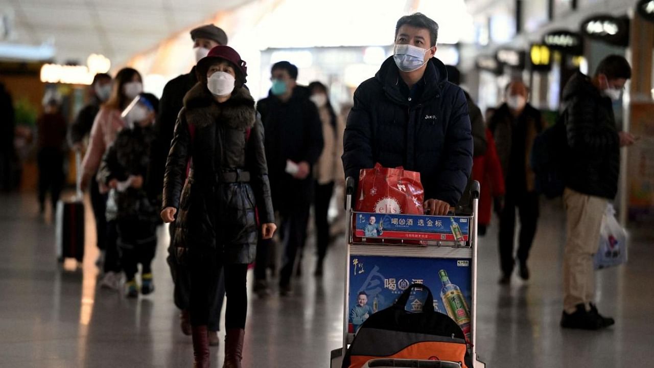 Passengers walk through a departure terminal of the international airport in Beijing. Credit: AFP