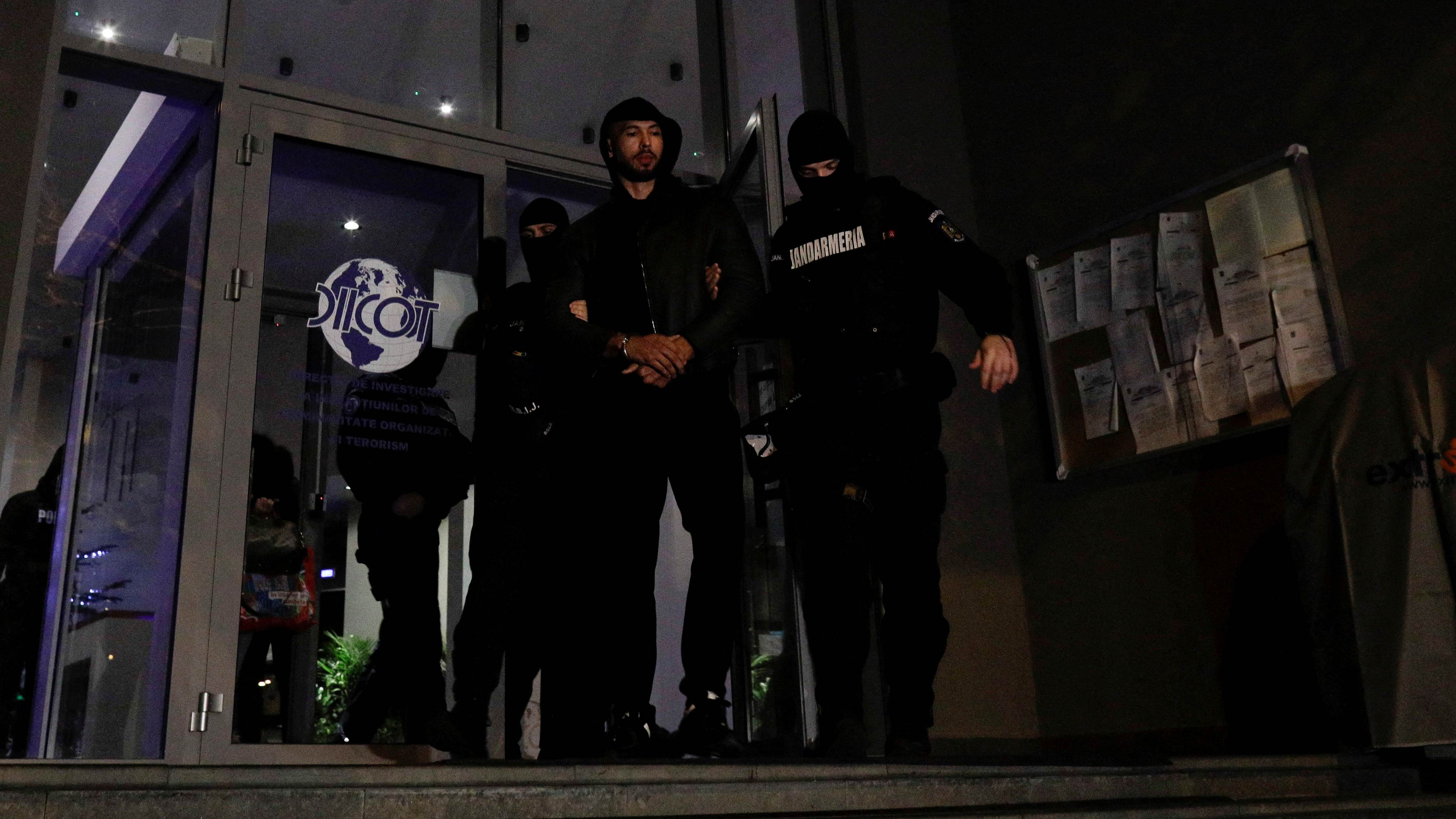 Andrew Tate escorted by police officers. Credit: Reuters Photo