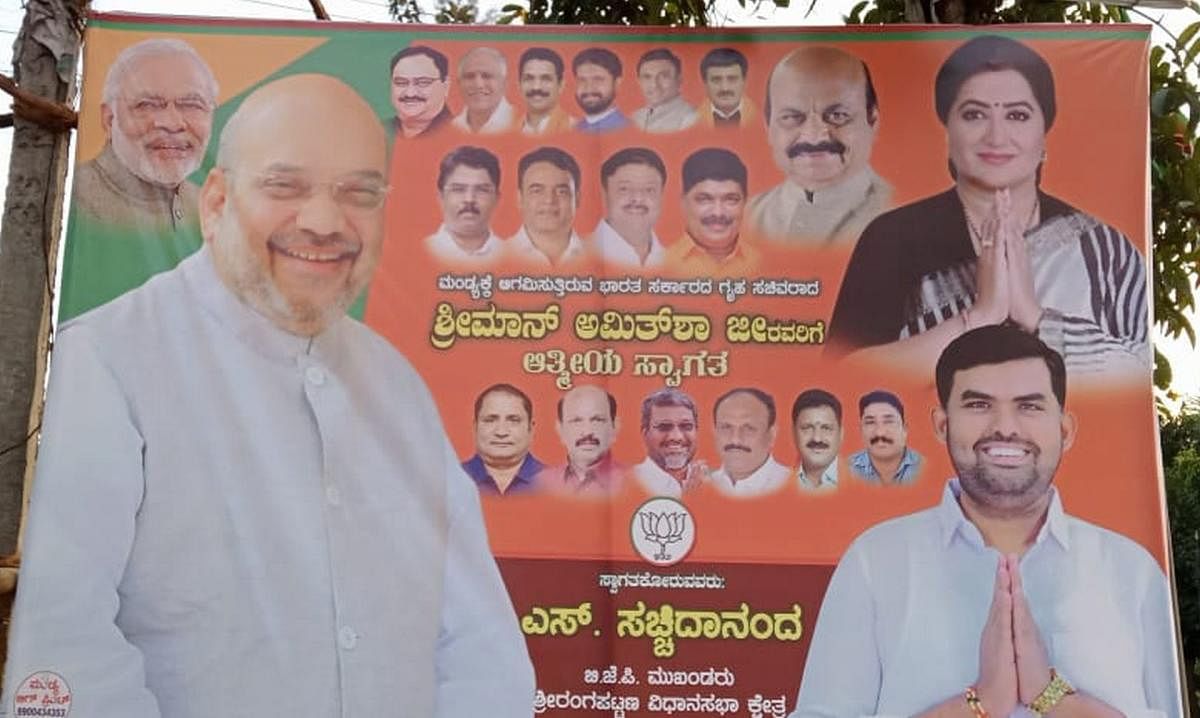 A banner with pictures of BJP leaders Amit Shah, Basavaraj Bommai and others with MP A Sumalatha, installed in Mandya. BJP ticket aspirant S Sachchidananda picture is also seen. Credit: DH Photo