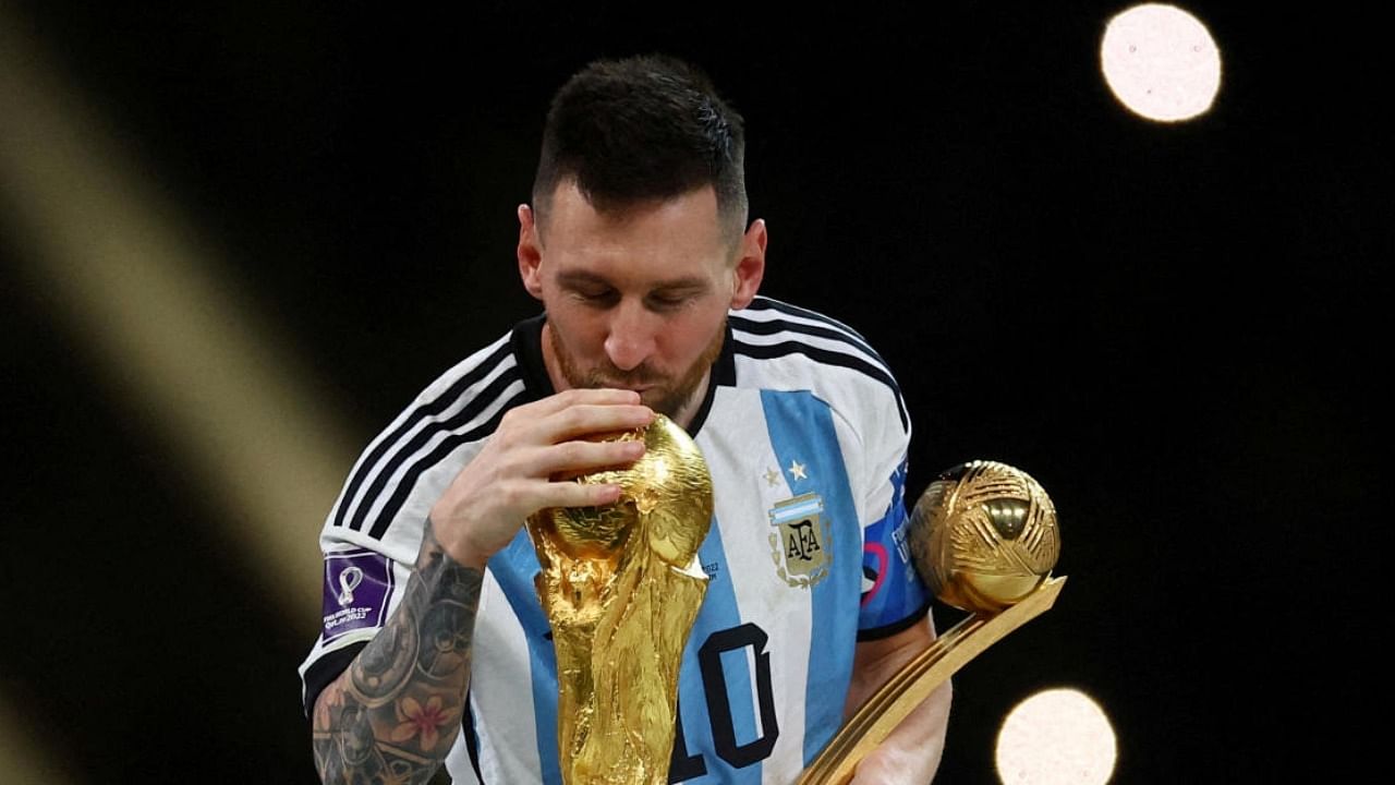  Lionel Messi kisses the World Cup trophy after receiving the Golden Ball award as he celebrates after winning the World Cup. Credit: Reuters Photo