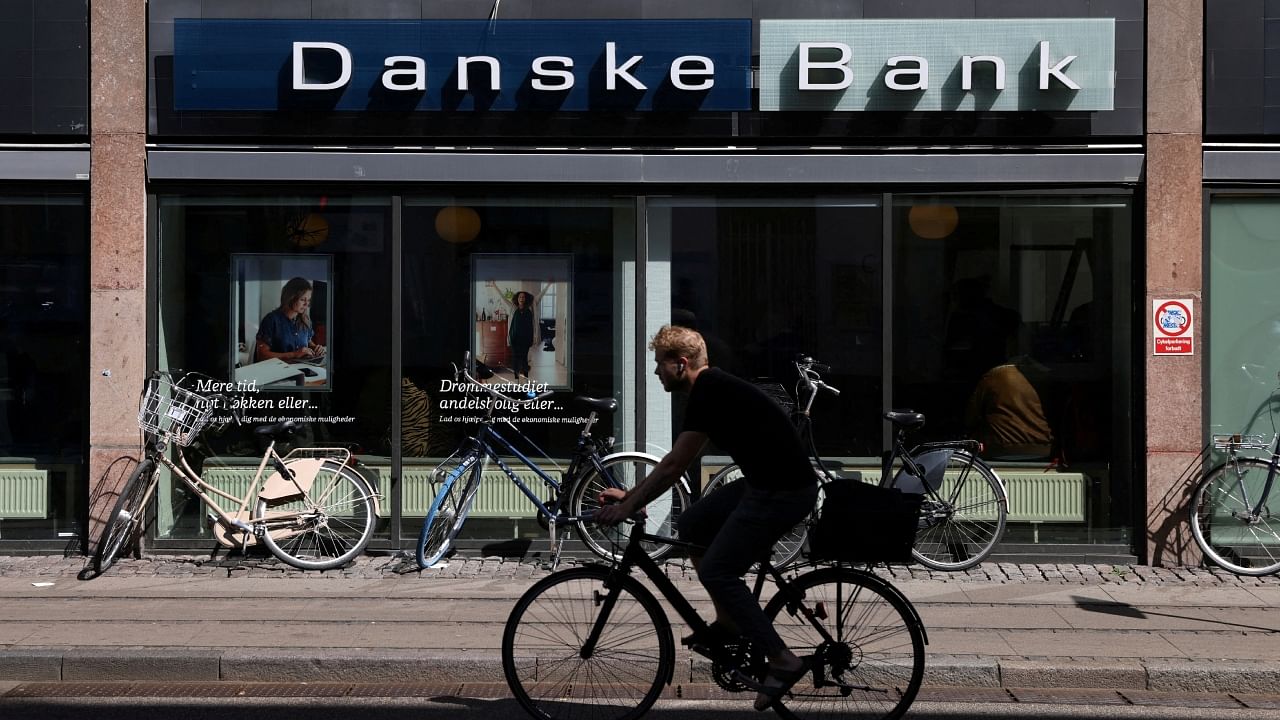A person rides a bicycle past a Danske Bank branch in Copenhagen, Denmark, July 29, 2022. Credit: Reuters File Photo