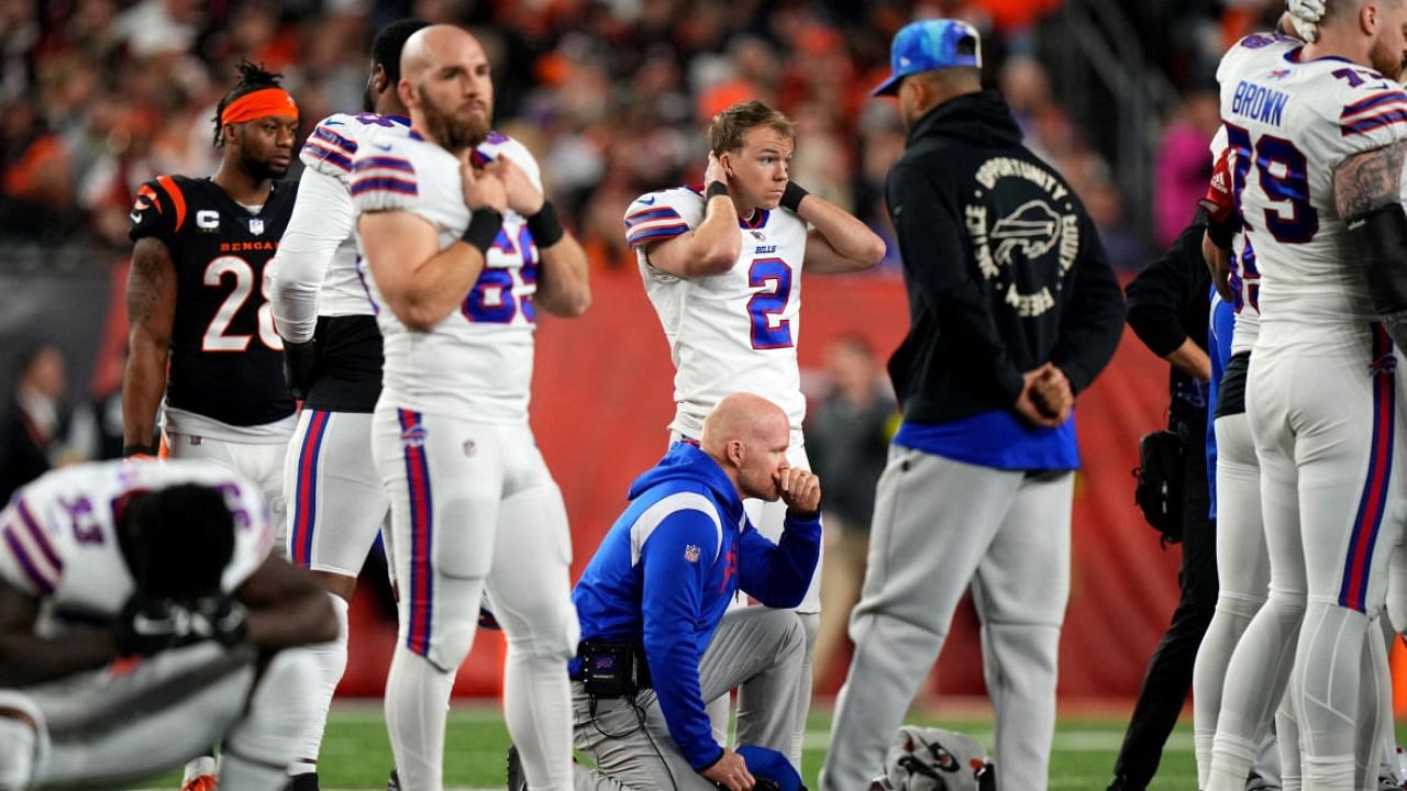The Buffalo Bills take a knee in prayer for Damar Hamlin who suffered a cardiac arrest while on the field. Credit: AFP