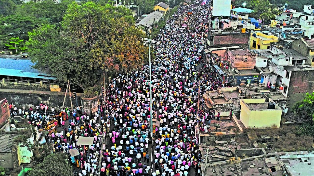 Thousands line up on either side of the road to pay their homage to 'Siddeshwara Appaji' during the procession of the mortal remains of the seer in Vijayapura on Tuesday. Credit: Special Arrangement