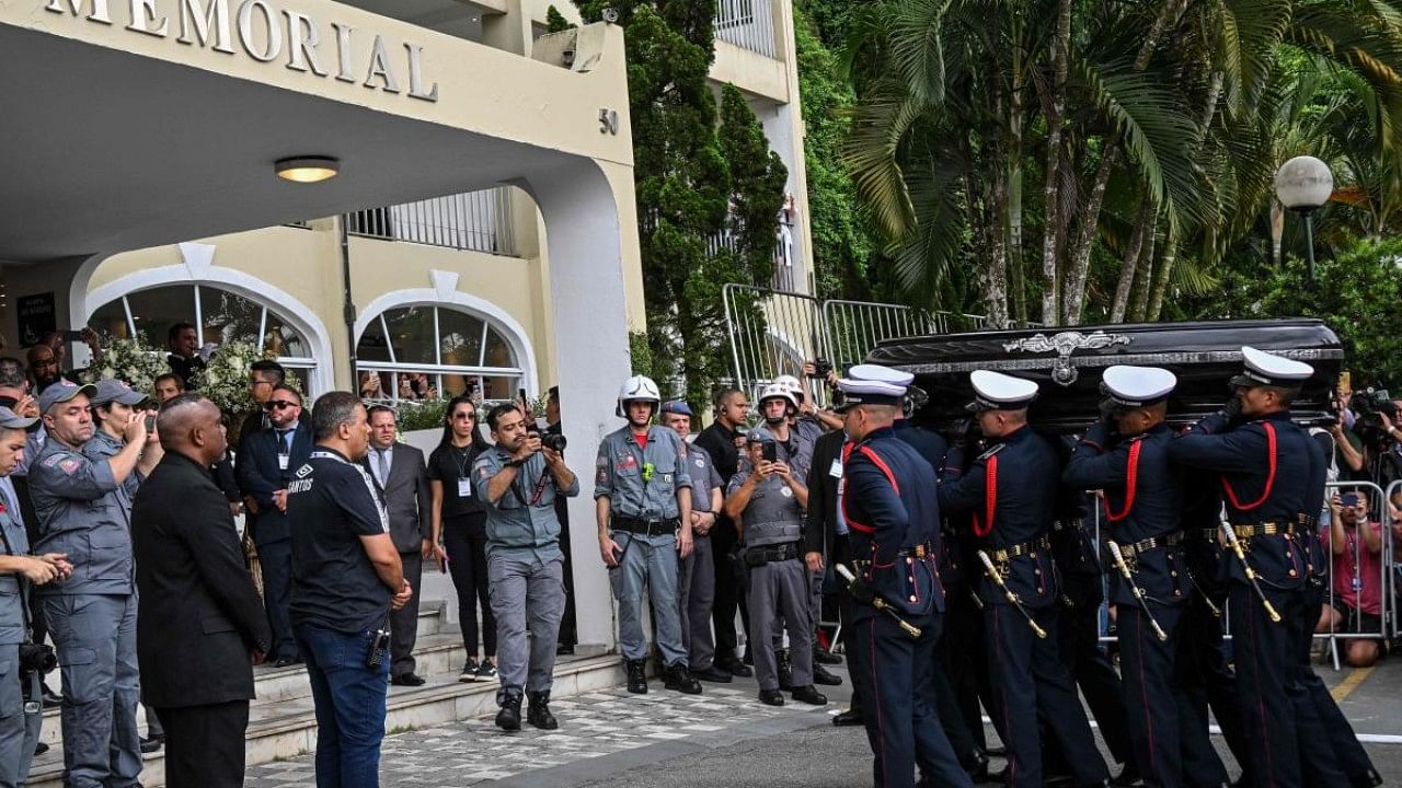 The coffin of the late Brazilian football star Pele arrives to the Santos' Memorial Cemetery after the funeral procession in Santos, Sao Paulo state, Brazil. Credit: AFP Photo