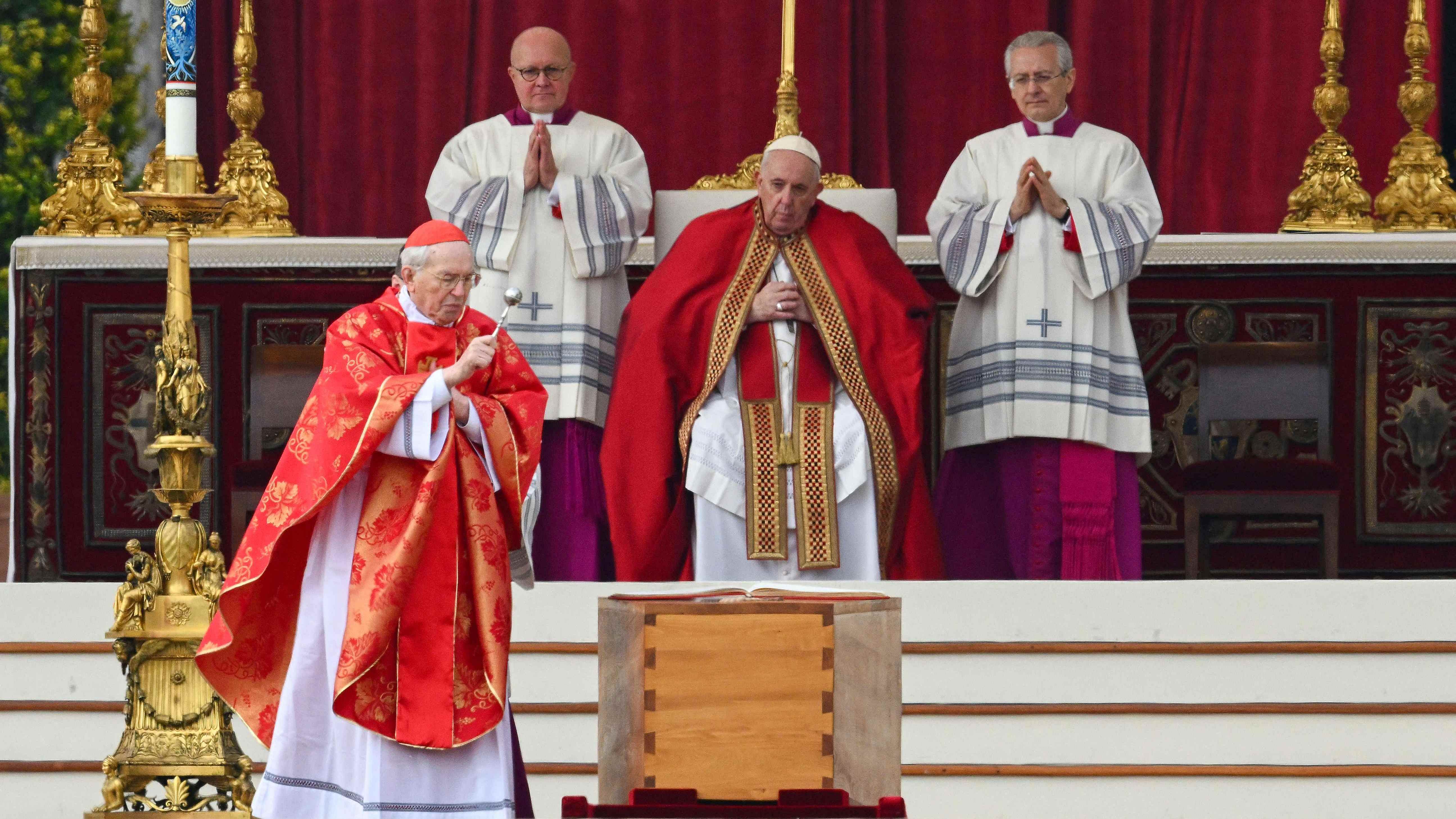 Italian Cardinal Giovanni Battista Re (L) blesses the coffin of Pope Emeritus Benedict XVI, as Pope Francis looks on (C) during his funeral mass at St. Peter's square in the Vatican. Credit: AFP Photo