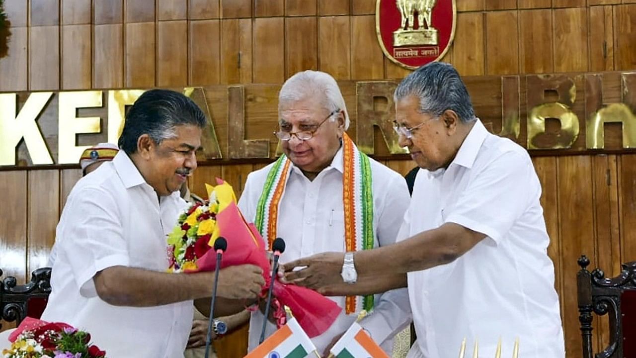Kerala Governor Arif Mohammad Khan and Chief Minister Pinarayi Vijayan present a bouquet to MLA Saji Cheriyan after the latter took oath as a state cabinet minister, at Raj Bhawan in Thiruvananthapuram. Credit: PTI Photo