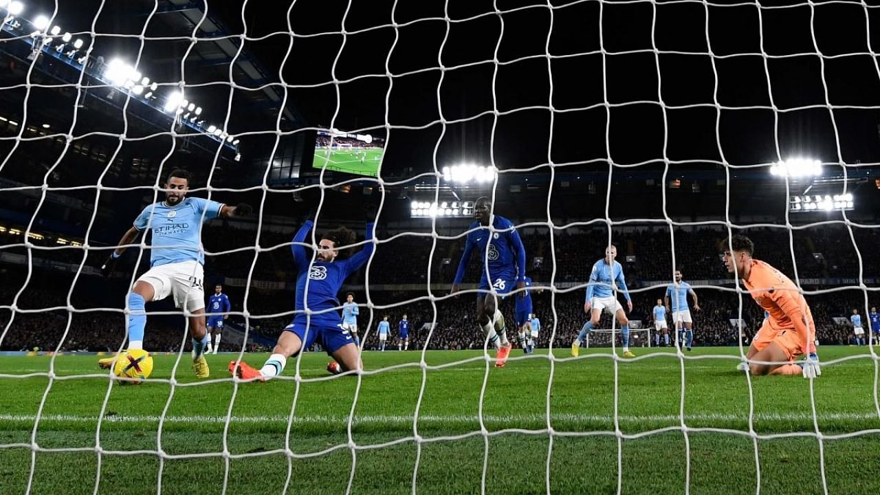 Manchester City's Algerian midfielder Riyad Mahrez (L) scores the opening goal during the English Premier League football match between Chelsea and Manchester City at Stamford Bridge in London on January 5, 2023. Credit: AFP Photo