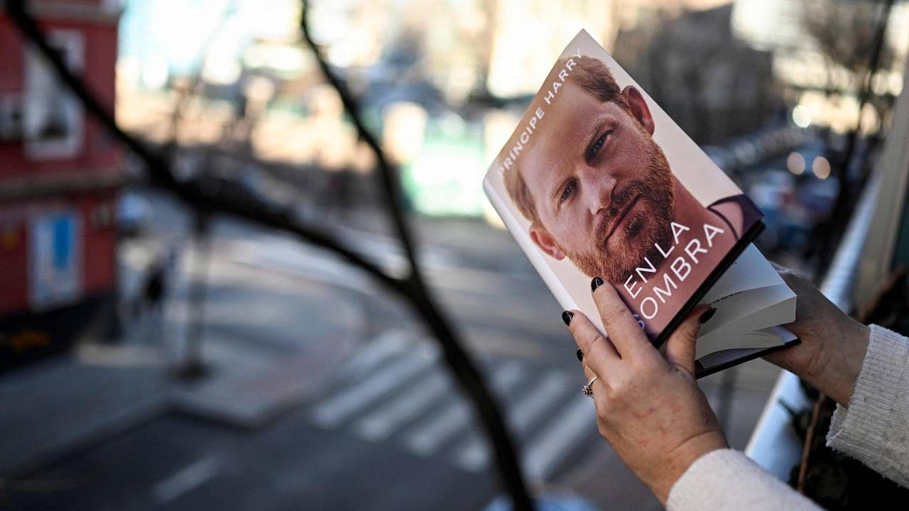 A woman leafs through the 'En la sombra' Spanish version of the book 'Spare' an autobiography by Britain's Prince Harry. Credit: AFP Photo