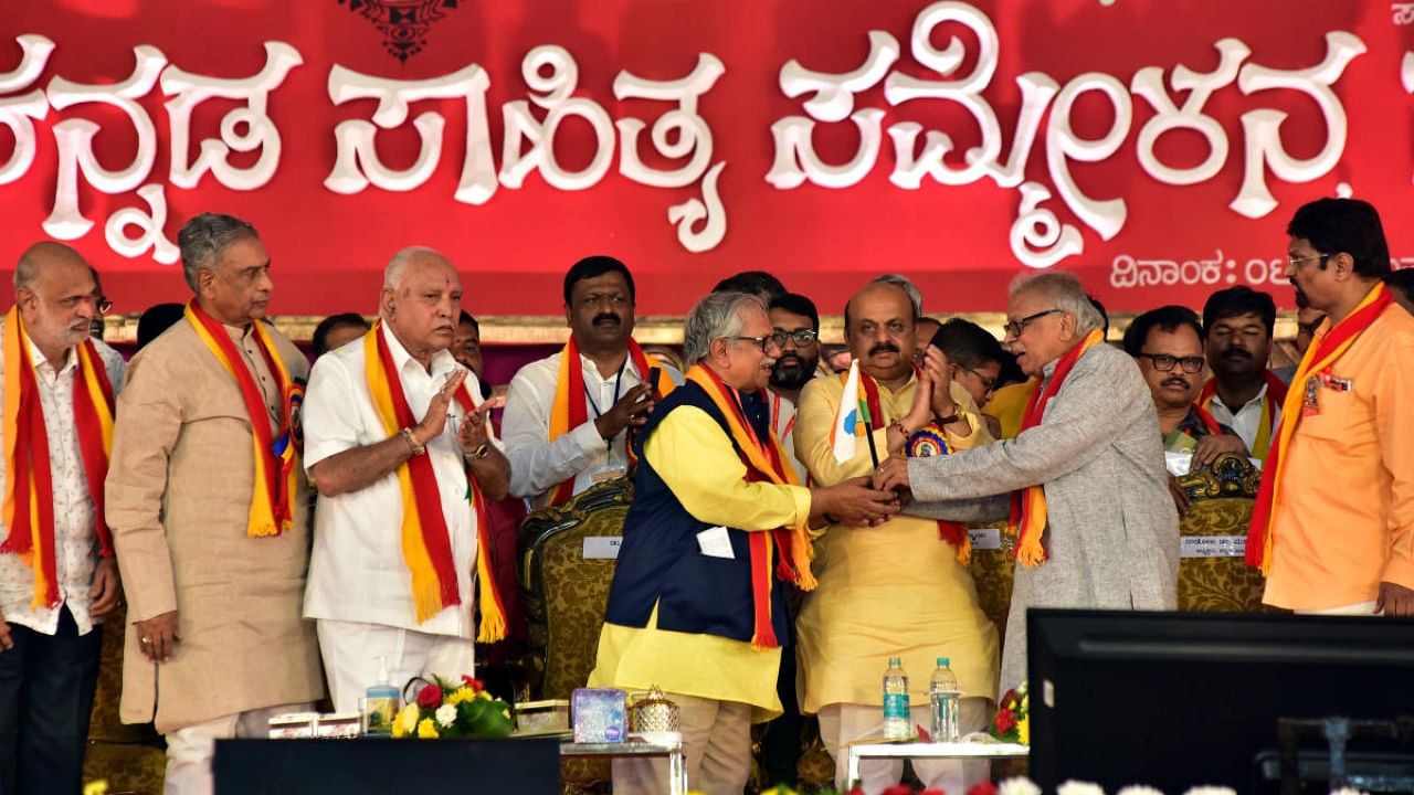 President of 86th Kannada Sahitya Sammelana Prof Doddarange Gowda receives the Kannada flag from Prof H S Venkatesh Murthy, the president of the previous literary meet, at the inaugural ceremony of the Sammelana in Haveri on Friday. Credit: DH Photo/Govindaraj Javali