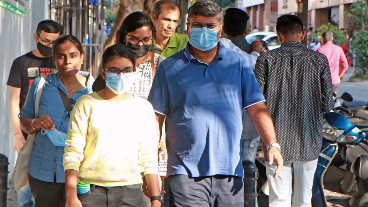 People mask up as they take a walk in the city amid rise in coronavirus cases in country. Credit: DH Photo